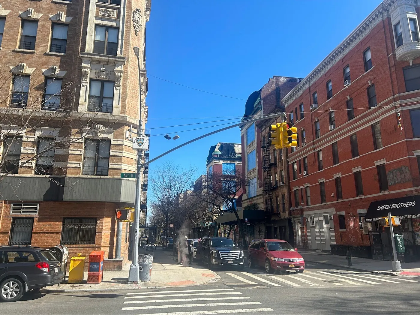 City corner in the East Village with a visible NYPD camera on the traffic and lightpole